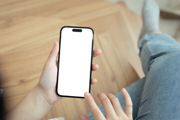 Close up of woman sitting with leg crossed holding a smartphone with a blank white screen