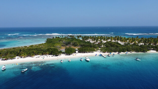 Aerial view of a small cay with crystal clear water on both sides