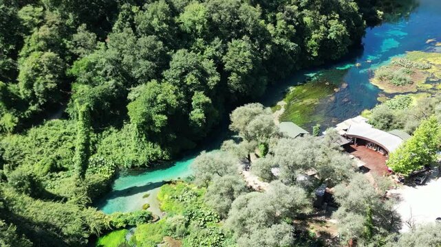 River coast dron bird view in Blue eye river, Albania. Green Seaweed leaves in Turquoise and green water river Bistrice scenic aerial view in Muzine, Finiq, Albania, Europe.