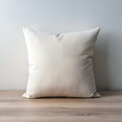 A plain white pillow on a light wood table. perfect for showcasing your design or branding.