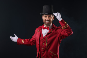 Portrait of showman in red costume and hat on black background © New Africa