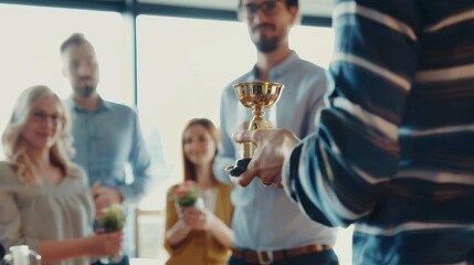 An individual proudly holds a golden trophy in front of a small, appreciative group of people.