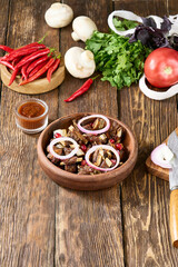 Rustic Georgian Chicken Tabaka on Ketsi with Onions and Vegetables on Wooden Background