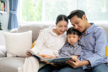 A family is happily reading a book together at home