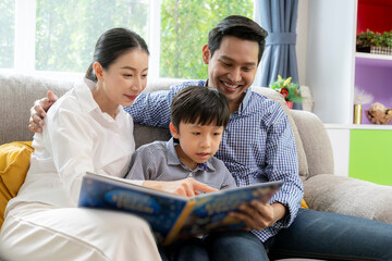 A family is happily reading a book together at home