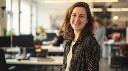 Fototapeta premium A smiling woman stands confidently in a busy office, conveying a sense of enthusiasm and engagement amid a productive work environment.