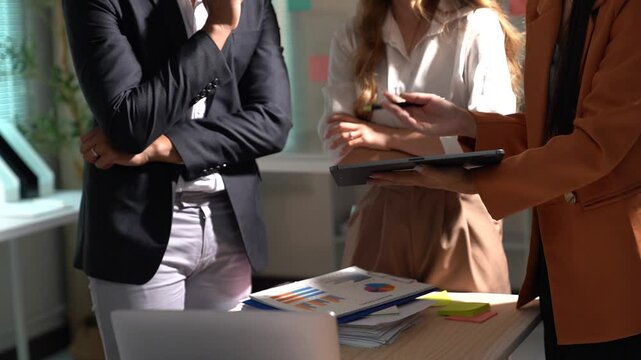 Two asian female ui/ux designers collaborate on a mobile application interface, discussing wireframe designs and sharing ideas in a creative office environment