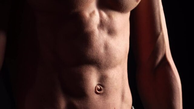Athletic Bodybuilder Man Show His Arms Torso and Abdominal Muscles. Fitness man showing muscle. Handsome strong athletic men pumping up back muscles workout fitness and bodybuilding concept. 