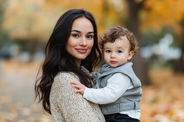 A mom and son walk in an autumn park, having fun together.