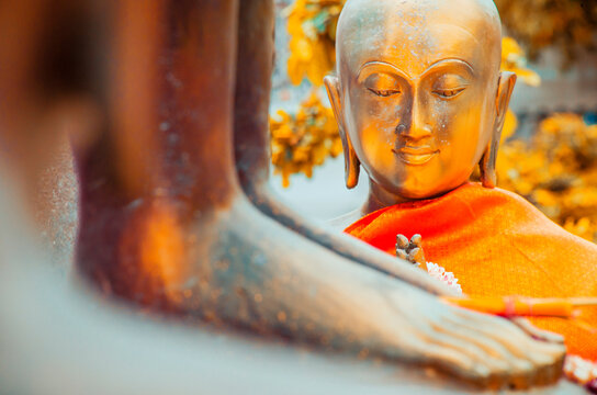 Statue of Buddha with folded hands in prayer.