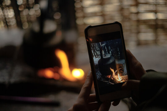 Person Photograph Kettle Over Fire with Smartphone