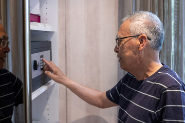 senior man opens safe with security code