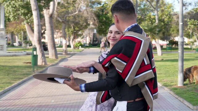 pareja de huasos bailando cueca chilena en la plaza de la ciudad