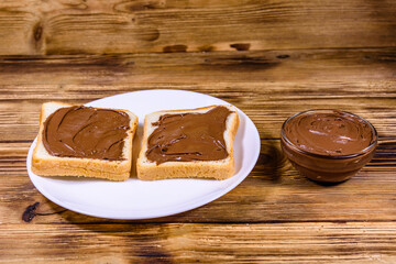Two sandwiches with chocolate spread on a white plate