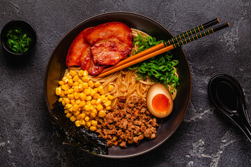 A bowl of ramen with noodles, meat and green onions.