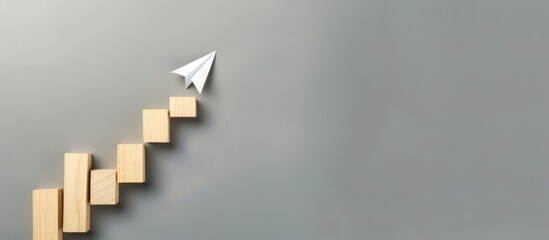 Rising arrow on wooden block and light gray background. Concept of growing or improving.