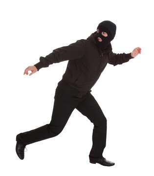 Caught in Action: Masked Man Makes a Dash in a White Room as Loses Pursuers