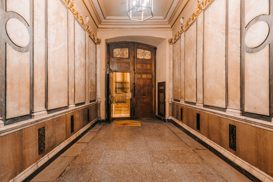 A spacious, well-lit hallway with beige walls and ornate molding