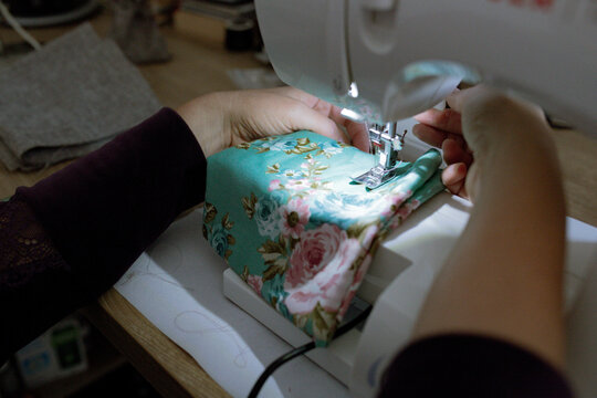 a woman sews on a sewing machine
