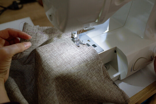 a woman sews on a sewing machine