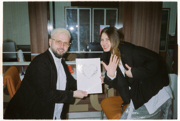 Classy young happy just married couple holding marriage certificate