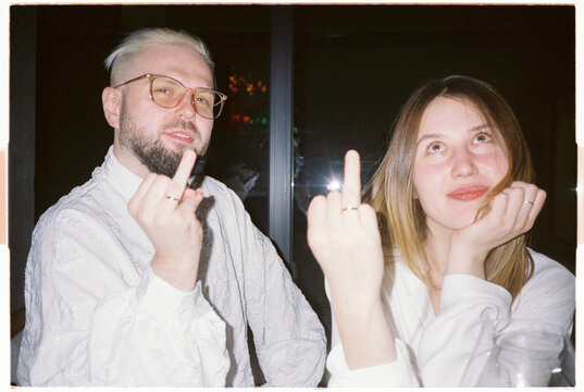 Joyful just married couple with ring fingers up