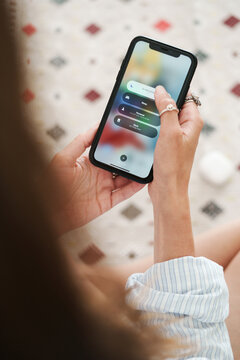 Woman Setting Phone to Do Not Disturb Mode for Uninterrupted Focus