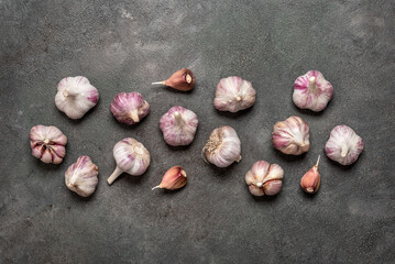 Fresh garlic border on dark rustic background, top view, flat lay,