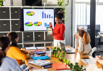 WOMAN TEACHING STATISTICS TO HER COLLEAGUES IN THE OFFICE
