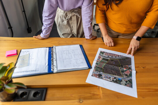 TWO WOMEN OBSERVE A DRAFT CONSTRUCTION PLANS