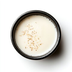 White liquid in a black bowl with brown specks on top