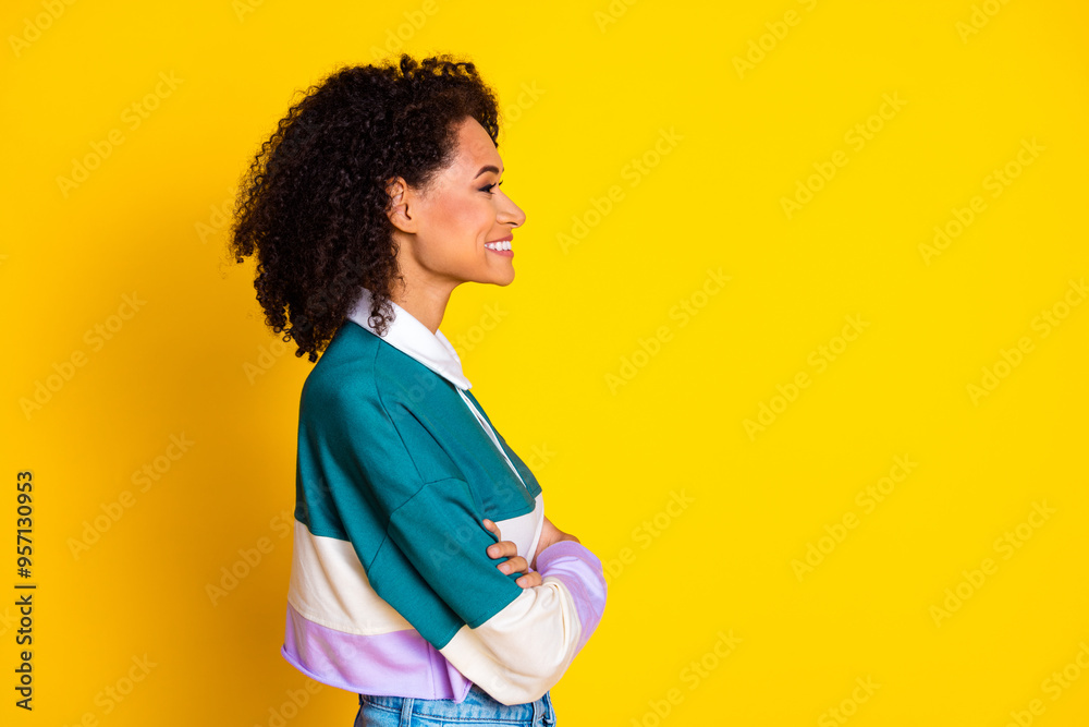 Wall mural Photo of lovely young lady profile crossed hands look empty space dressed stylish striped garment isolated on yellow color background