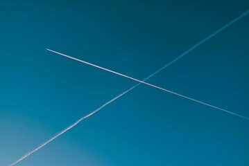 Crossing jet contrails in the clear blue sky