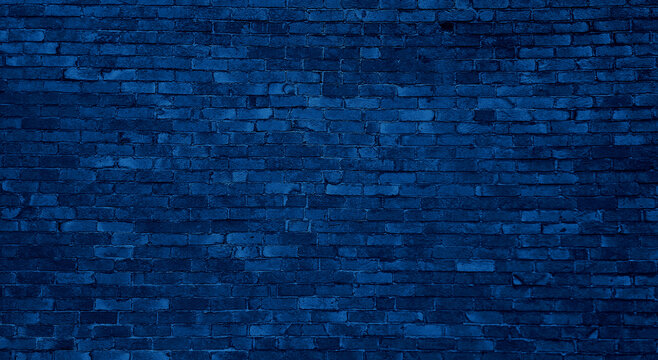old dark blue brick wall of an old architecture building. brick wall texture. navy blue masonry of stone blocks use as background with blank space for design.