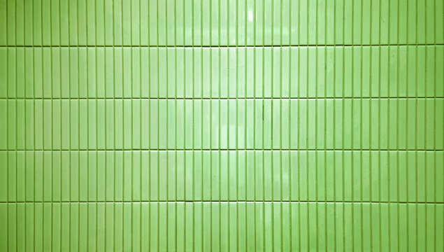 close up image of vintage green ceramic clay wall tiles use as background with blank space for design. abstract interior wall finishing material. tiles background. subway brick in vertical pattern.