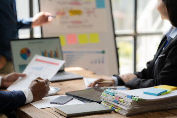 Business Meeting: Data-Driven Decisions: A focused and professional business meeting, captured in this photo, showcases a team reviewing data on a whiteboard and laptop. The scene exudes professionali