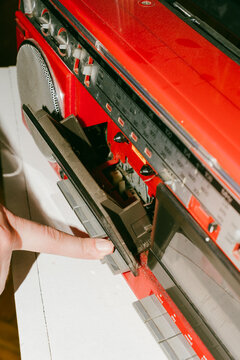 Finger Pressing Button on Vintage Red Radio Cassette Player