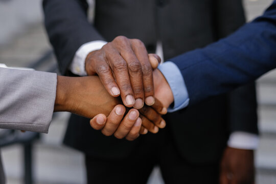 Business associates forming hand stack outdoors
