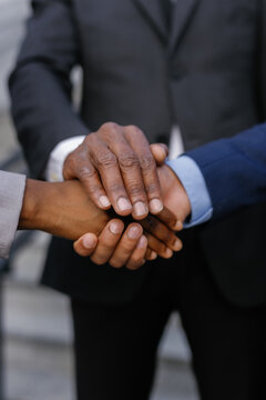 Businessman and his colleagues forming hand stack during meeting