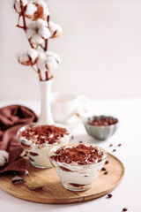 Traditional Italian dessert tiramisu in glasses on white table. Soft focus