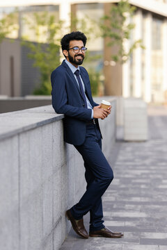Office worker standing against parapet wall during coffee break