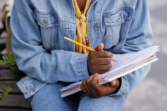 Anonymous woman filling out paper form outdoors