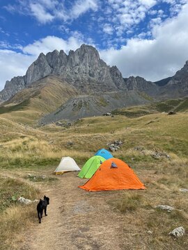 A Row Of Tents Set Up In Front Of A Mountain Range On A Sunny Day
