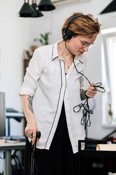 Stylish Woman with MS Holding Headphones Cable
