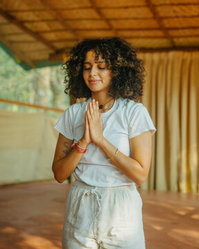 A woman praying with palms together in front of her chest