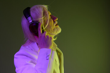 Man with long white hair and beard wearing headphones, enjoying music against a stylish gradient background in green and purple hues