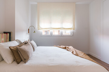 A modern, minimalist bedroom with a neatly made double bed