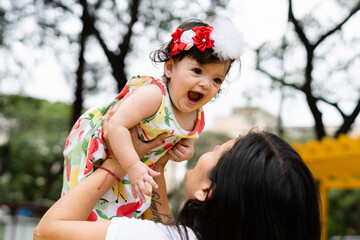 A baby smiling with her mother