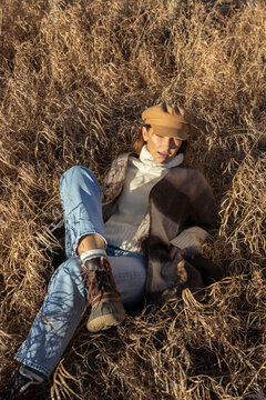 Outdoors scene featuring a stylish woman in a fall outfit