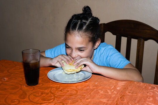 A girl eating an arepa 